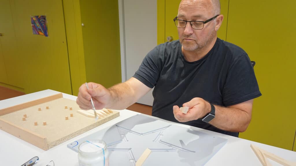 Mitarbeitender der Talentwerkstatt beim Verleimen der Sterne.