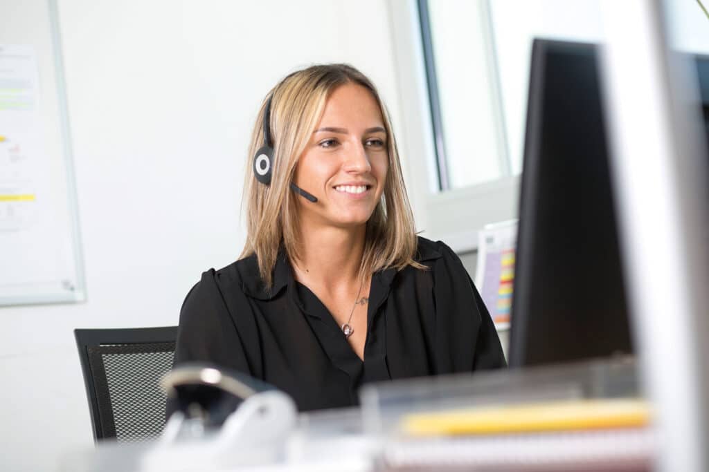 Junge Frau mit Headphone arbeitet am Computer