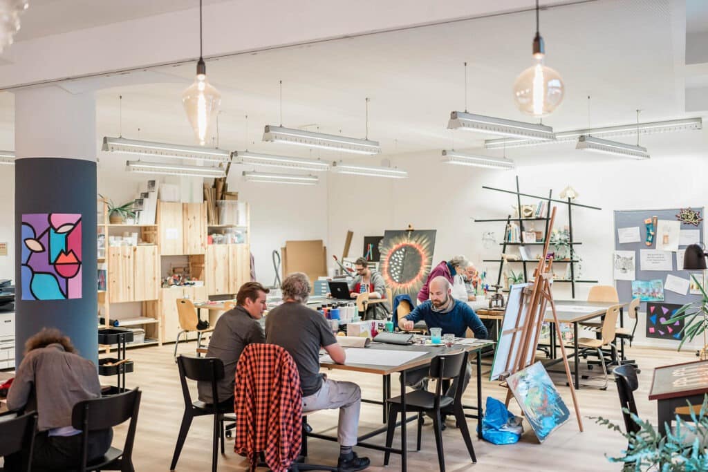 Menschen beim kreativen Arbeiten im Tageszentrum.