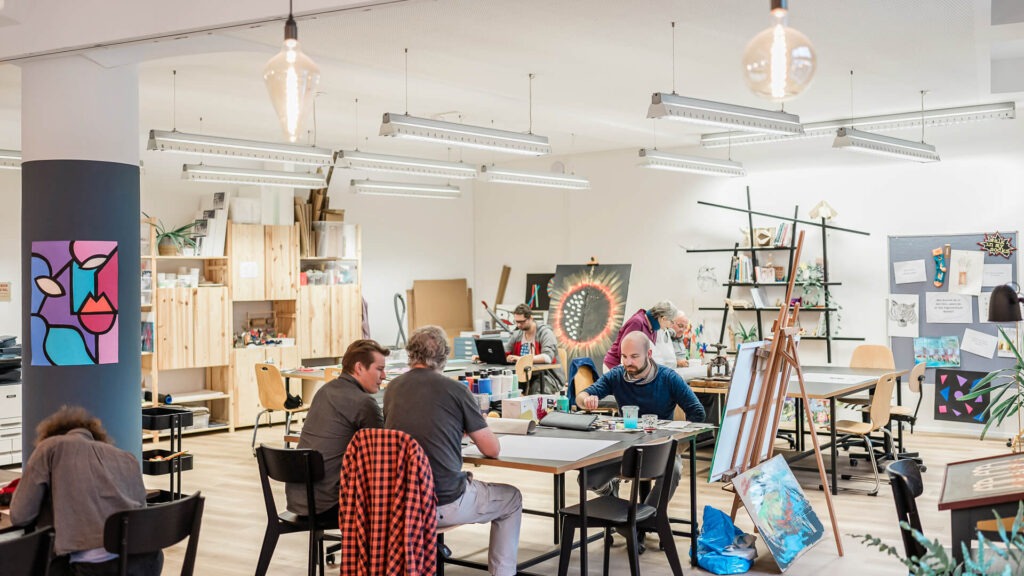 Menschen beim kreativen Arbeiten im Tageszentrum.