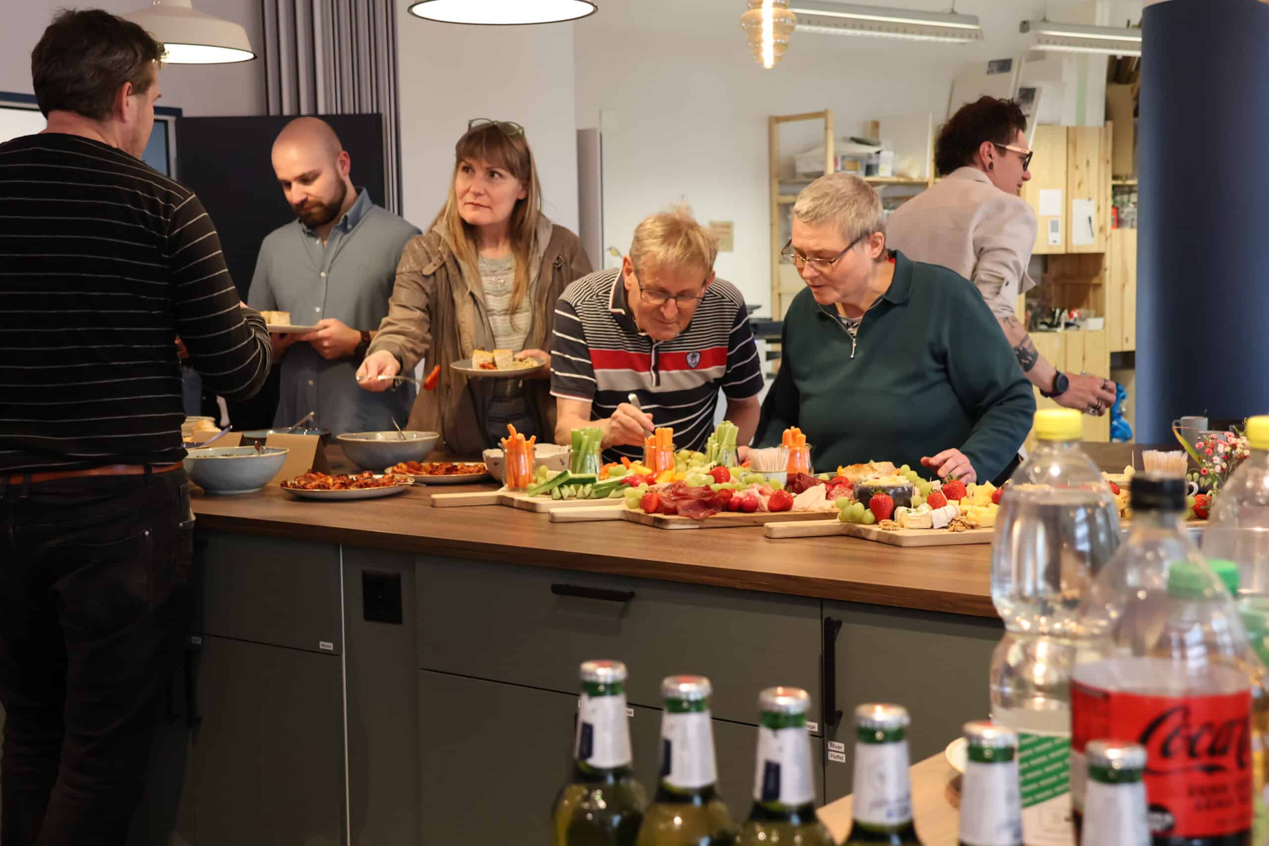 Verschiedene Gäste im Tageszentrum am Buffet.