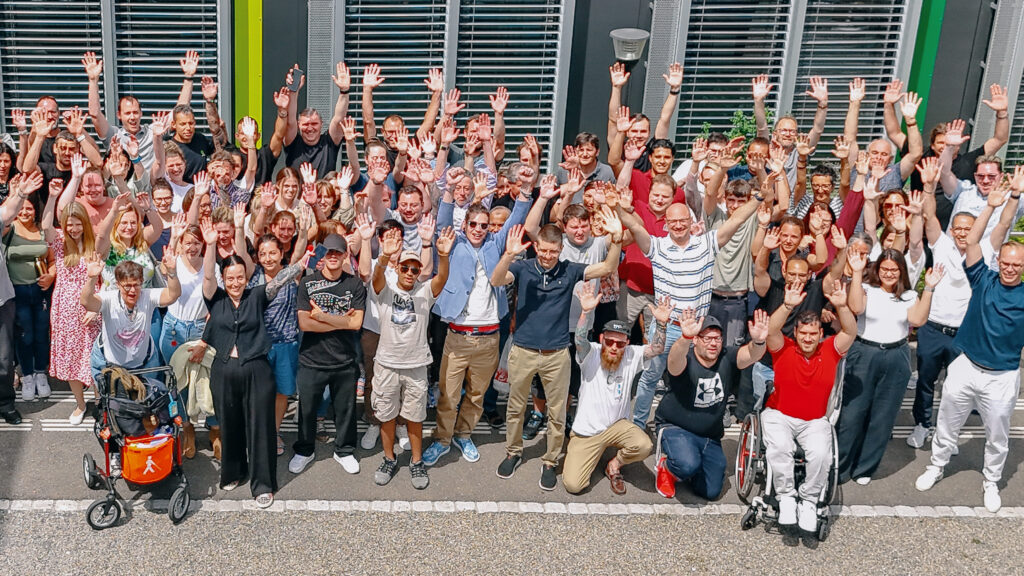 Ein Teil unserer engagierten Mitarbeitenden feiert die 4-Sterne-Auszeichnung im EFE-Assessment – von oben festgehalten und mit einem herzlichen Winken in die Zukunft.